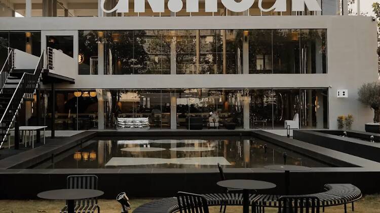 UNHOUR cafe in Bangkok with brutalist concrete aesthetic and iconic furniture design